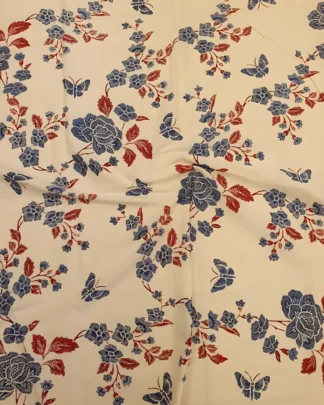 Sarung batik tulis motif bunga dan kupu-kupu biru di atas kain katun primissima putih yang elegan.