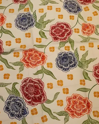 Motif mawar merah dan biru yang mekar di atas kain batik katun primissima putih, memberikan nuansa taman yang ceria dan anggun.