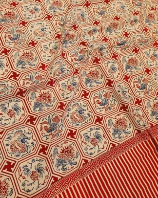 Kain batik sarung wanita dari katun primissima dengan motif medali burung hong dalam nuansa merah, biru, dan krem, dibentangkan di ruang kerja pembatik.