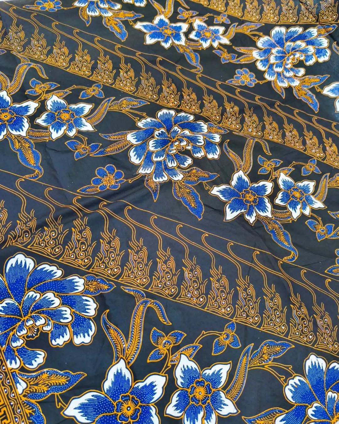 Kain batik sarung wanita motif bunga biru dan putih di atas dasar hitam, bahan katun primissima yang elegan.