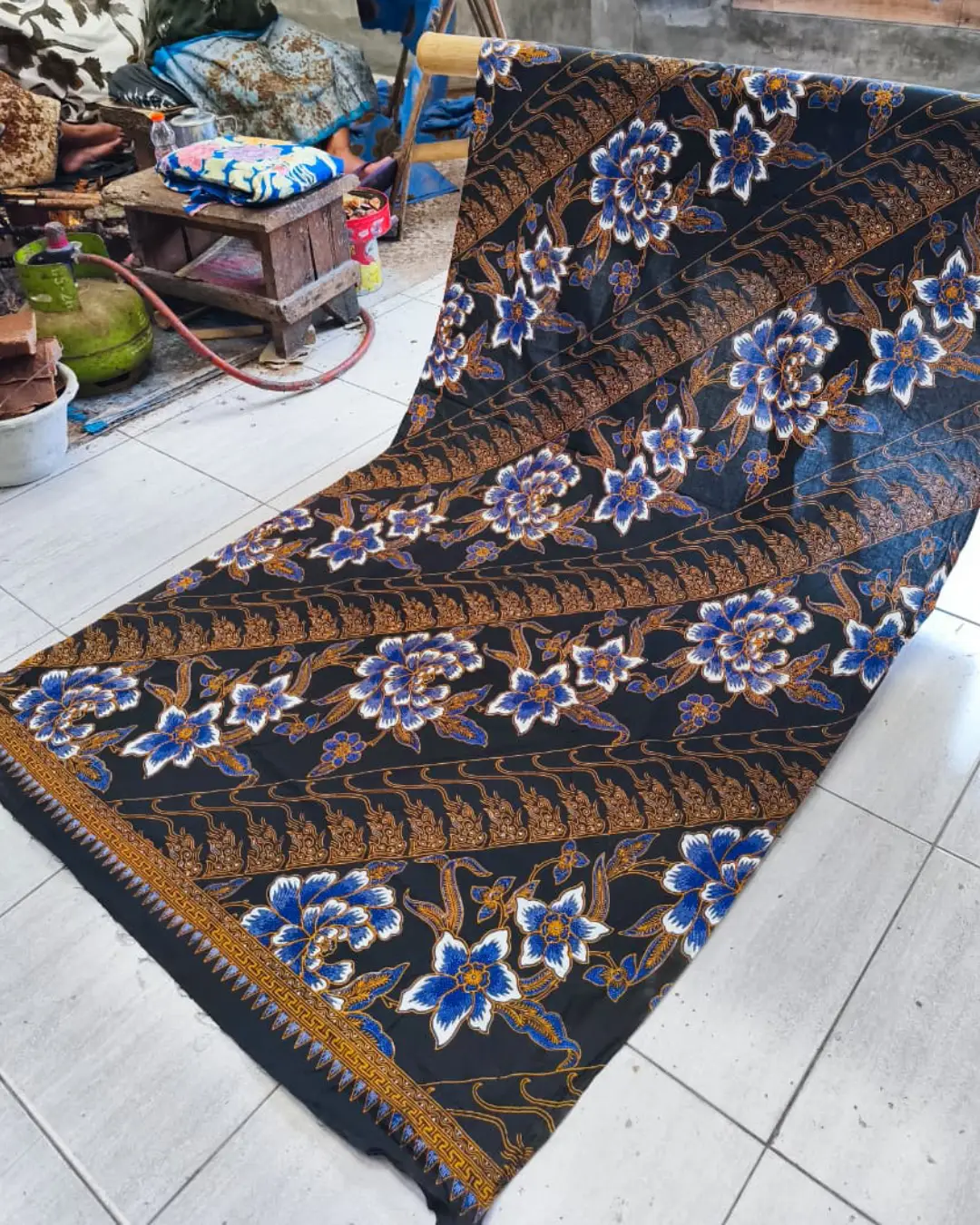 Kain batik sarung wanita motif bunga biru dan putih di atas dasar hitam, bahan katun primissima yang elegan.
