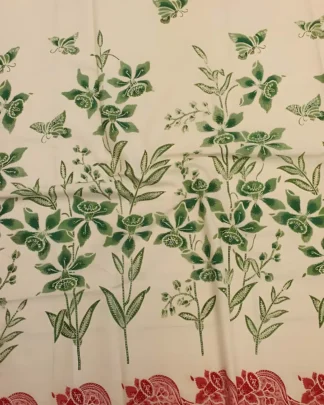 Motif dedaunan hijau dengan tepian merah muda di atas kain batik sarung bahan katun primissima putih.