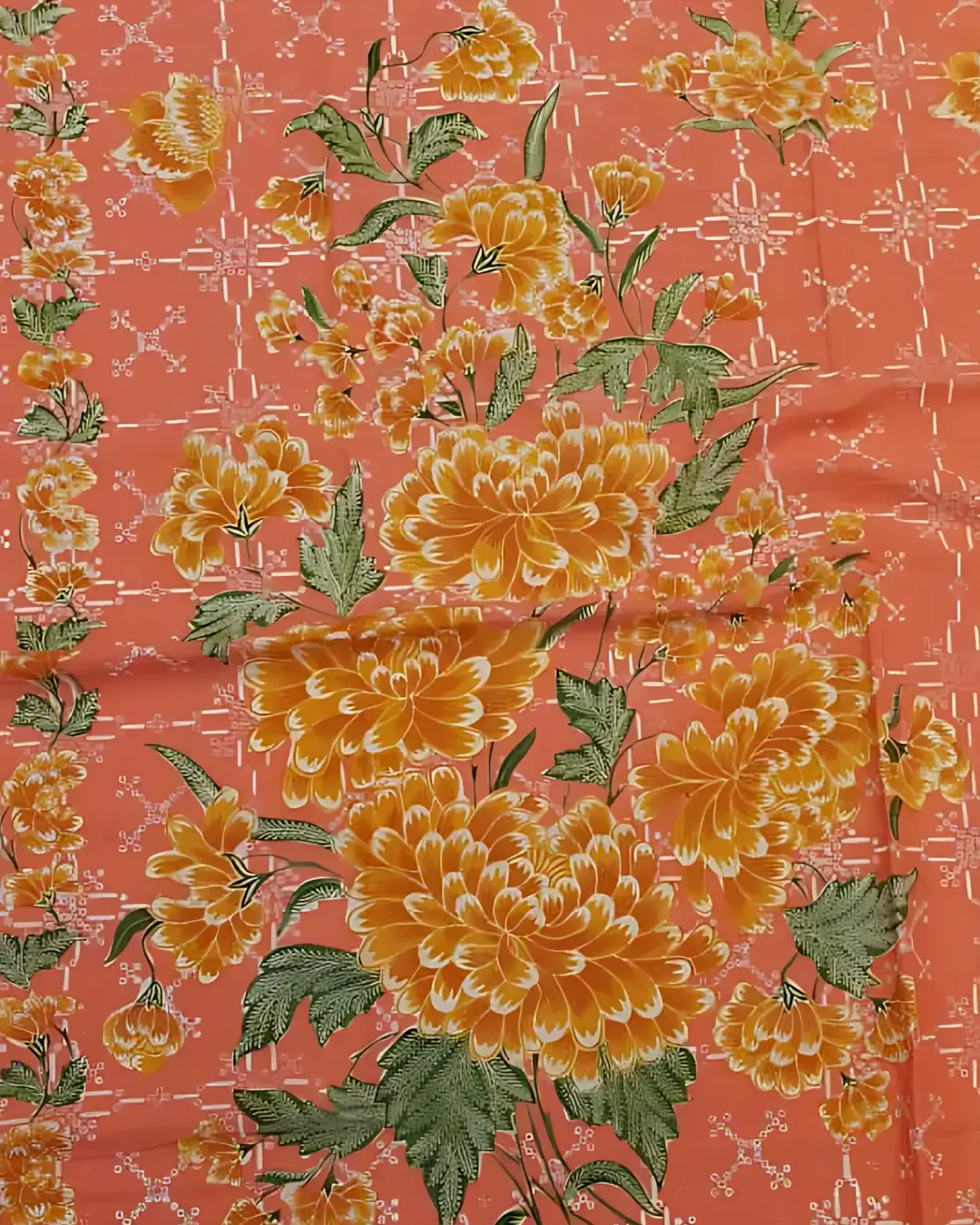 Sarung batik tulis katun primissima dengan motif bunga mekar berwarna kuning keemasan di atas dasar kain jingga yang hangat.